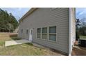 Back exterior view with light siding, a small patio, and level yard at 3005 Stonebrook Cv, Austell, GA 30106