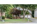 Beautiful two-story brick home with an attached two-car garage, mature trees, and a well-manicured lawn at 3335 Maple Terrace Dr, Suwanee, GA 30024