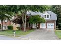 Attractive two-story brick home featuring an attached garage, lush trees, and a well-kept lawn at 3335 Maple Terrace Dr, Suwanee, GA 30024