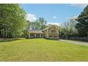 Charming two-story home with yellow siding, green shutters, and a well-manicured front lawn at 1522 Sprayberry Dr, Marietta, GA 30066