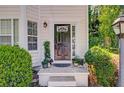 Inviting front door with sidelights and decorative plants creating a warm welcome at 4420 Thorngate Ln, Acworth, GA 30101
