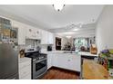 Bright kitchen features stainless steel appliances, white cabinets, and hardwood floors at 4420 Thorngate Ln, Acworth, GA 30101