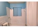 Bathroom featuring tiled walls, a toilet, a shower and a blue painted wall at 1895 Thomasville Se Dr, Atlanta, GA 30315