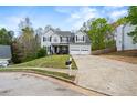 Traditional two-story home with a two-car garage, nicely landscaped front yard, and long driveway at 2077 Alcovy Trace Way, Lawrenceville, GA 30045