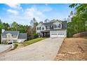 Traditional two-story home with a two-car garage, landscaped front yard, long driveway, and blue sky at 2077 Alcovy Trace Way, Lawrenceville, GA 30045