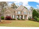 Charming two-story brick home boasts a well-manicured lawn, shutters, and welcoming front porch at 111 Glen Trl, Woodstock, GA 30188
