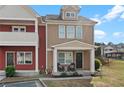 Attractive townhome boasting a cozy front porch with chairs and a decorative wreath at 1736 Brookside Lay Cir, Norcross, GA 30093