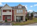 Inviting townhome with a covered front porch seating area and manicured lawn at 1736 Brookside Lay Cir, Norcross, GA 30093