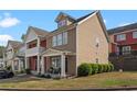 Well-maintained townhome showcases a covered porch with seating and neat greenery at 1736 Brookside Lay Cir, Norcross, GA 30093