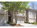 Well-lit townhouses boast driveway, garage, and meticulously manicured front yard at 2251 W Village Se Ln, Smyrna, GA 30080