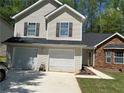 Charming townhome with stone facade, two-car garage, and manicured lawn at 3505 Oakshire Se Way, Atlanta, GA 30354