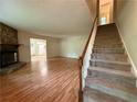 Bright living room featuring wood floors, stone fireplace, and staircase at 3013 Barcelona Way, Conyers, GA 30012