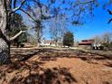 Expansive lot featuring mature trees and an outbuilding set against a clear blue sky at 1828 Kellogg Creek Rd, Acworth, GA 30102