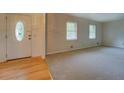 Bright living room features carpeted flooring, two windows, and a view of the home's front door at 2198 Kings Forest Se Dr, Conyers, GA 30013
