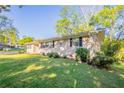 View of brick exterior of home with a well-maintained lawn and landscaping at 3905 Kirksford Dr, Decatur, GA 30035