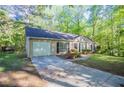 Single-story home with attached garage, long driveway, and fresh landscaping at 2800 Macon Se Dr, Atlanta, GA 30354