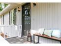 Inviting front porch with bench, pillows, decor and a welcoming wreath on the front door at 5819 Stonehaven Nw Dr, Kennesaw, GA 30152