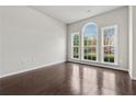 Living room features hardwood floors, fresh paint and a large arched window overlooking the front yard at 104 Marlow Dr, Woodstock, GA 30188
