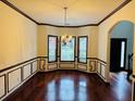 Formal dining area featuring gleaming hardwood floors and a stylish chandelier at 5589 Dendy Trc, Fairburn, GA 30213
