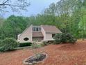 Charming two-story home featuring manicured landscaping and unique architectural details nestled among mature trees at 4487 Park Place Ter, Marietta, GA 30066