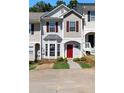 Charming townhome featuring a red front door, bay window, and well-maintained landscaping at 73 Timber Ridge Dr, Cartersville, GA 30121