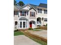 Charming townhome featuring a red front door, bay window, and well-maintained landscaping at 73 Timber Ridge Dr, Cartersville, GA 30121