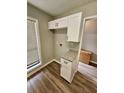 Convenient kitchen area with granite counters, white cabinets, and stylish wood-look flooring at 907 River Run Dr, Atlanta, GA 30350