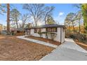 Charming single-story home with concrete walkway, complemented by lush landscaping and mature trees at 2241 Glendale Dr, Decatur, GA 30032
