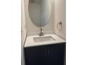 Modern half bathroom features a sleek vanity with a white countertop and an oval mirror at 3131 Leyland Ct, Decatur, GA 30034