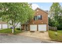 Traditional brick home featuring an attached two car garage and mature tree at 3131 Leyland Ct, Decatur, GA 30034