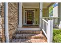 Inviting front porch with brick steps, white columns, and a decorative front door, enhancing curb appeal at 416 Wilfawn Way, Avondale Estates, GA 30002