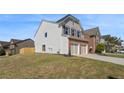 Lovely two-story home featuring a brick and siding exterior, two-car garage, and spacious front yard at 5620 Weddington Drive Dr, Cumming, GA 30040