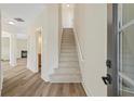 Inviting foyer with hardwood floors, staircase, and open view into the living room with a fireplace at 5620 Weddington Drive Dr, Cumming, GA 30040
