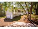 View of charming home with a white porch, showcasing an attached two-car garage and well-kept landscaping at 670 Maplelake Dr, Acworth, GA 30101