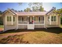 Inviting single-story home boasts a cozy front porch, large windows, and a well-manicured lawn at 670 Maplelake Dr, Acworth, GA 30101