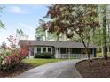 Charming home exterior with landscaped front yard and long driveway, showcasing curb appeal and privacy at 7650 Rico Rd, Chattahoochee Hills, GA 30268