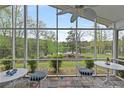 Inviting screened porch with lake views, offering a serene outdoor living space with slate tile flooring at 7650 Rico Rd, Chattahoochee Hills, GA 30268