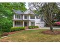 Lovely two-story home featuring a covered porch, black shutters, and a lush green lawn at 1043 Middlebrooke Dr, Canton, GA 30115
