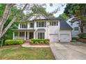 Traditional two-story home with a two-car garage, covered porch, and well-manicured lawn at 1043 Middlebrooke Dr, Canton, GA 30115
