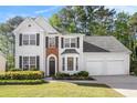 Charming two-story home with a well-manicured lawn and elegant architectural details like a brick arch at 1916 Oakwood Grove Dr, Snellville, GA 30078