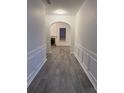 Hallway with grey wood floors and arched doorways with white trim and paint at 1916 Oakwood Grove Dr, Snellville, GA 30078