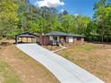 Beautifully renovated home with a long driveway, carport, and a freshly landscaped front yard at 5017 Spring Hill Dr, Sugar Hill, GA 30518