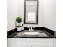 Elegant bathroom vanity featuring a black granite countertop and modern mirror at 7154 Sw Chara Sw Ln, Atlanta, GA 30331