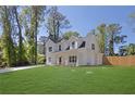 Charming exterior view of a two-story white house with a large lawn, surrounded by mature trees at 1353 Midlawn Dr, Decatur, GA 30032