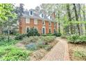 Inviting brick home with a well-manicured front yard and a charming brick walkway, nestled among trees at 5884 Hammersmith Rd, Stone Mountain, GA 30087