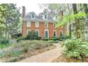 Charming red brick two-story home with dormer windows and professionally landscaped front yard at 5884 Hammersmith Rd, Stone Mountain, GA 30087