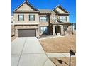 Charming two-story home featuring a brick and siding facade, attached garage, and well-manicured lawn at 3716 Derringer Rdg, Loganville, GA 30052