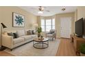 Relaxing living room offers natural light with hardwood floors, stylish furniture, and neutral color palette at 7112 Brookview Way, Riverdale, GA 30274