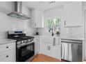 Charming kitchen features white cabinets, stainless steel appliances, and a subway tile backsplash at 912 Fairburn Nw Rd, Atlanta, GA 30331