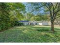 Traditional home with a well-kept lawn and mature trees providing ample shade at 2340 Rolling Acres Sw Dr, Conyers, GA 30094